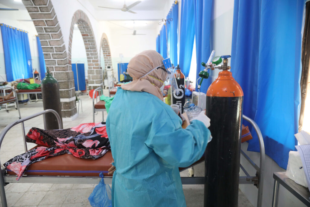 Frontline responders at work, preparing oxygen bottles at an emergency maternity ward.