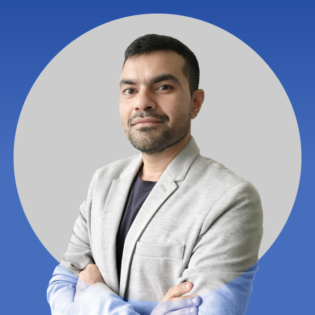 Portrait of Scope's Design Lead Palash Singh wearing a grey blazer against a blue and grey background.